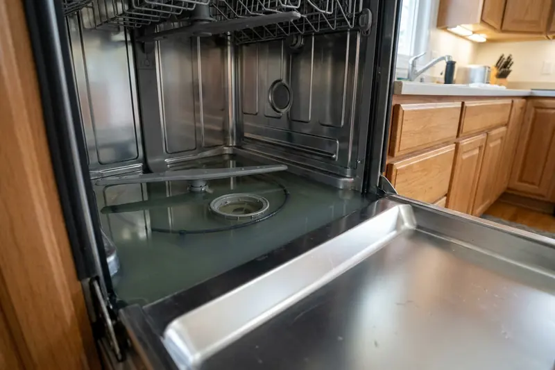 Standing water covering the floor of a dishwasher tub