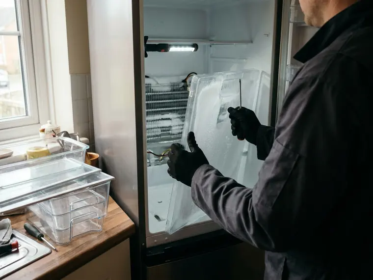 Technician removing the inner panel to reach a frosted evaporator coil